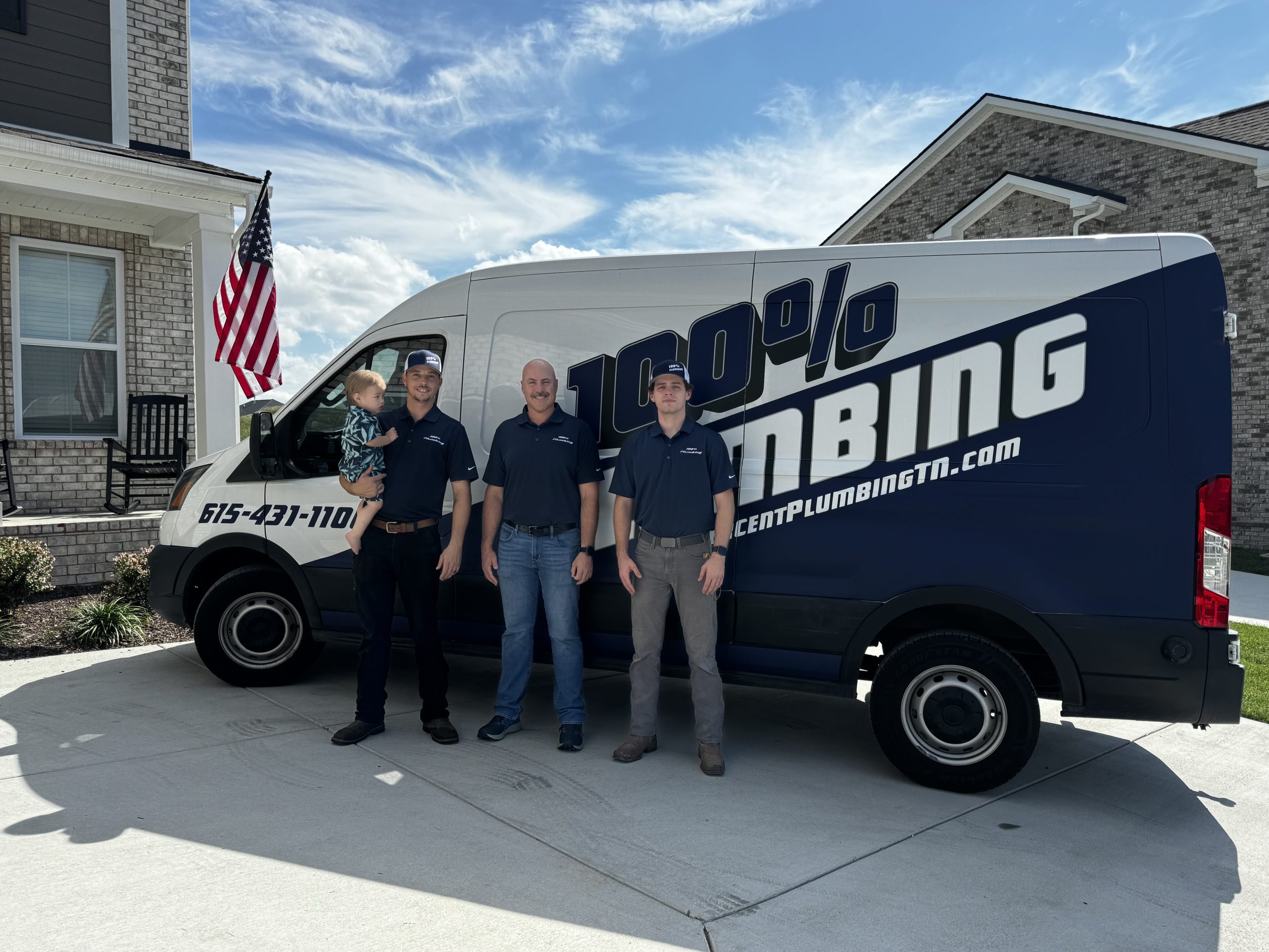 100 Percent Plumbing technicians standing with company van in front of a Nashville-area home